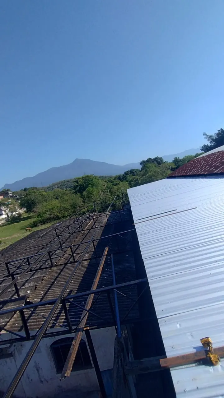 Telhas metálicas sendo colocadas sobre a estrutura de aço